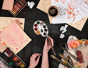 Image showing paint brushes and tubes of oil paints on wooden background