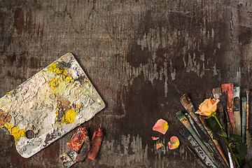 Image showing paint brushes and tubes of oil paints on wooden background