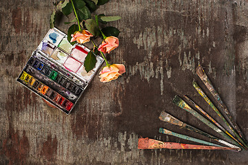 Image showing paint brushes and tubes of oil paints on wooden background