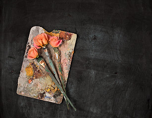 Image showing paint brushes and tubes of oil paints on wooden background