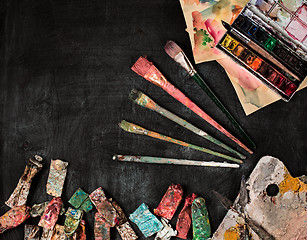 Image showing paint brushes and tubes of oil paints on wooden background