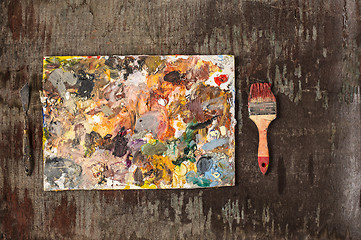 Image showing paint brushes and tubes of oil paints on wooden background