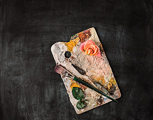 Image showing paint brushes and tubes of oil paints on wooden background