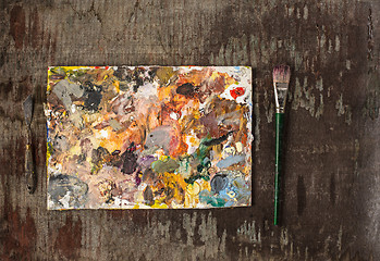 Image showing paint brushes and tubes of oil paints on wooden background