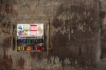 Image showing paint brushes and tubes of oil paints on wooden background