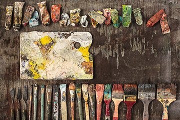 Image showing paint brushes and tubes of oil paints on wooden background