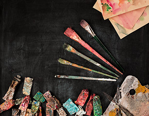 Image showing paint brushes and tubes of oil paints on wooden background