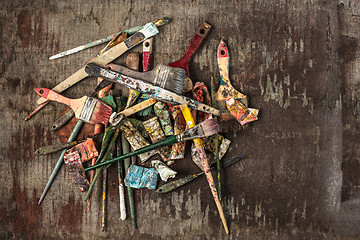 Image showing paint brushes and tubes of oil paints on wooden background