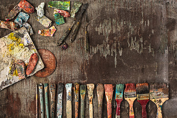 Image showing paint brushes and tubes of oil paints on wooden background