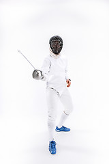 Image showing Man wearing fencing suit practicing with sword against gray