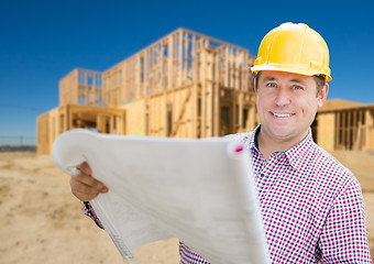 Image showing Smiling Contractor Wearing Hardhat Holding Blueprints at Home Co