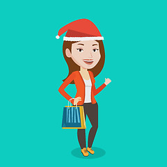 Image showing Woman in santa hat shopping for christmas gifts.