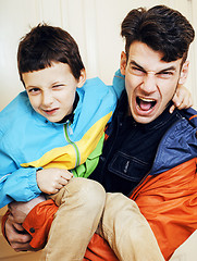 Image showing young handsome hipster father with his son fooling around at hom