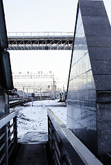 Image showing landscape with railway with trains, lot of steel rafters at sunset