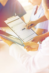 Image showing close up of doctors with clipboard at hospital