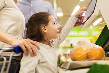 Image showing family weighing oranges on scale at grocery store