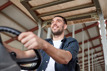 Image showing man or farmer driving tractor at farm