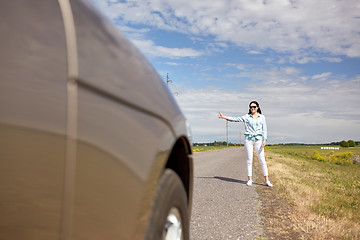 Image showing woman hitchhiking and stopping car with thumbs up