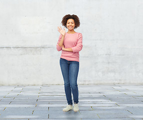 Image showing happy african american young woman waving hand