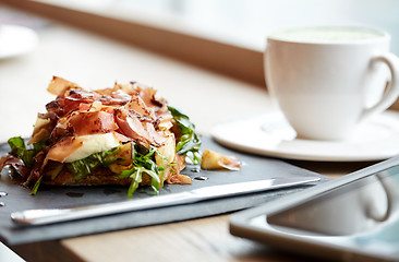 Image showing prosciutto ham salad on stone plate at restaurant