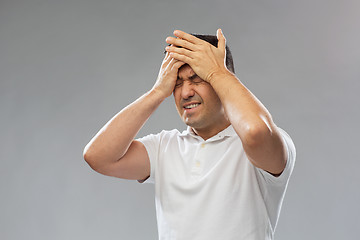 Image showing unhappy man suffering from head ache