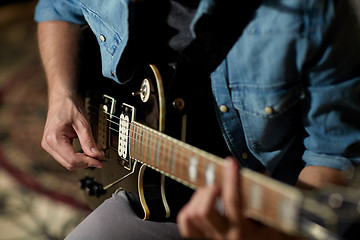 Image showing close up of man playing guitar at studio rehearsal