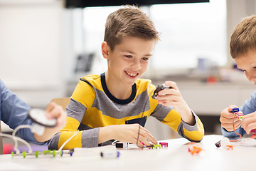 Image showing happy boy building robot at robotics school