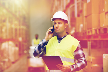 Image showing man with clipboard and smartphone at warehouse