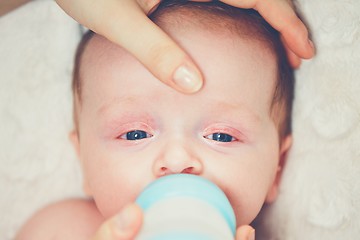 Image showing Hungry baby drinking milk