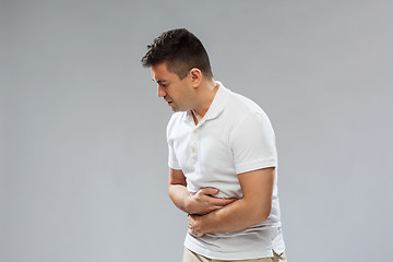 Image showing unhappy man suffering from stomach ache