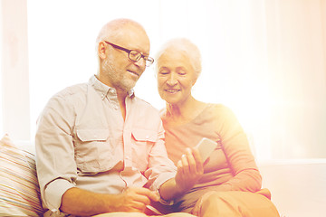 Image showing happy senior couple with smartphone at home
