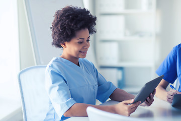 Image showing happy female doctor or nurse with tablet pc