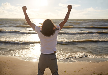 Image showing man with rised fist on beach