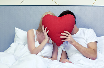 Image showing happy couple in bed with red heart shape pillow