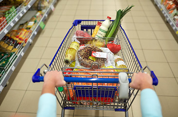 Image showing woman with food in shopping cart at supermarket