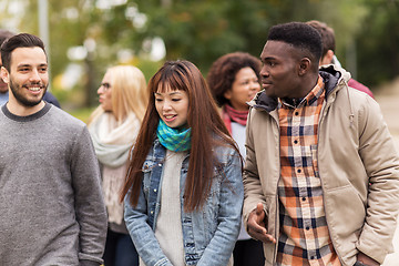 Image showing happy friends walking along autumn park