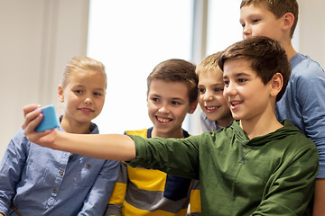 Image showing group of happy kids taking selfie with smartphone