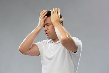 Image showing unhappy man suffering from head ache