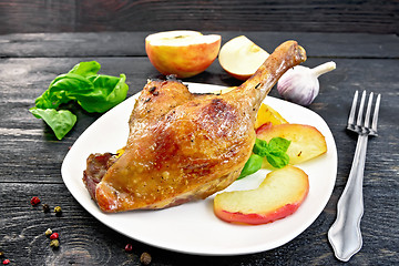 Image showing Duck leg with apple and basil on board