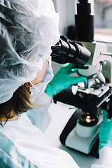 Image showing Scientist working in laboratory with microscope