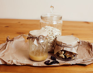 Image showing real comfort wooden kitchen with breakfast ingredients close up in glass, honey, oatmeal, milk, muesli, morning food