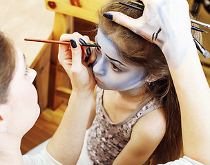 Image showing little cute child making facepaint on birthday party, zombie Apocalypse facepainting, halloween preparing concept, lifestyle people 