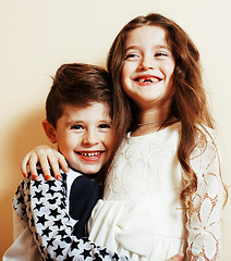 Image showing little cute boy and girl hugging playing on white background, ha