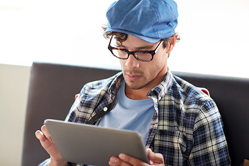 Image showing man with tablet pc sitting at cafe table