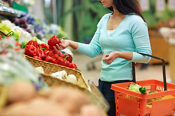 Image showing woman with basket buying peppers at grocery store