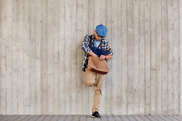 Image showing hipster man looking for something in his bag