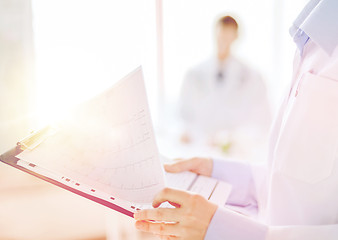 Image showing female holding clipboard with cardiogram