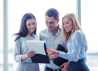 Image showing business team looking at clipboard