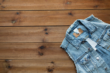 Image showing close up of denim waistcoat with price tag on wood