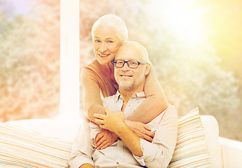 Image showing happy senior couple hugging on sofa